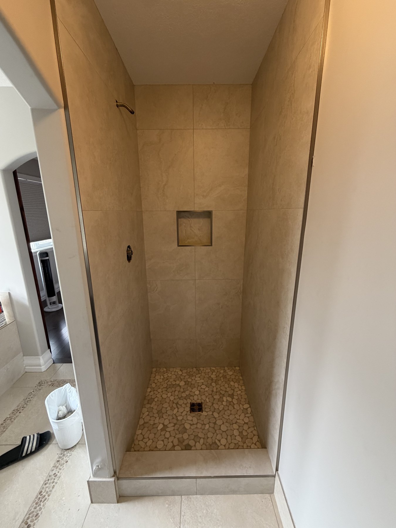 Natural stone shower with pebble tile floor