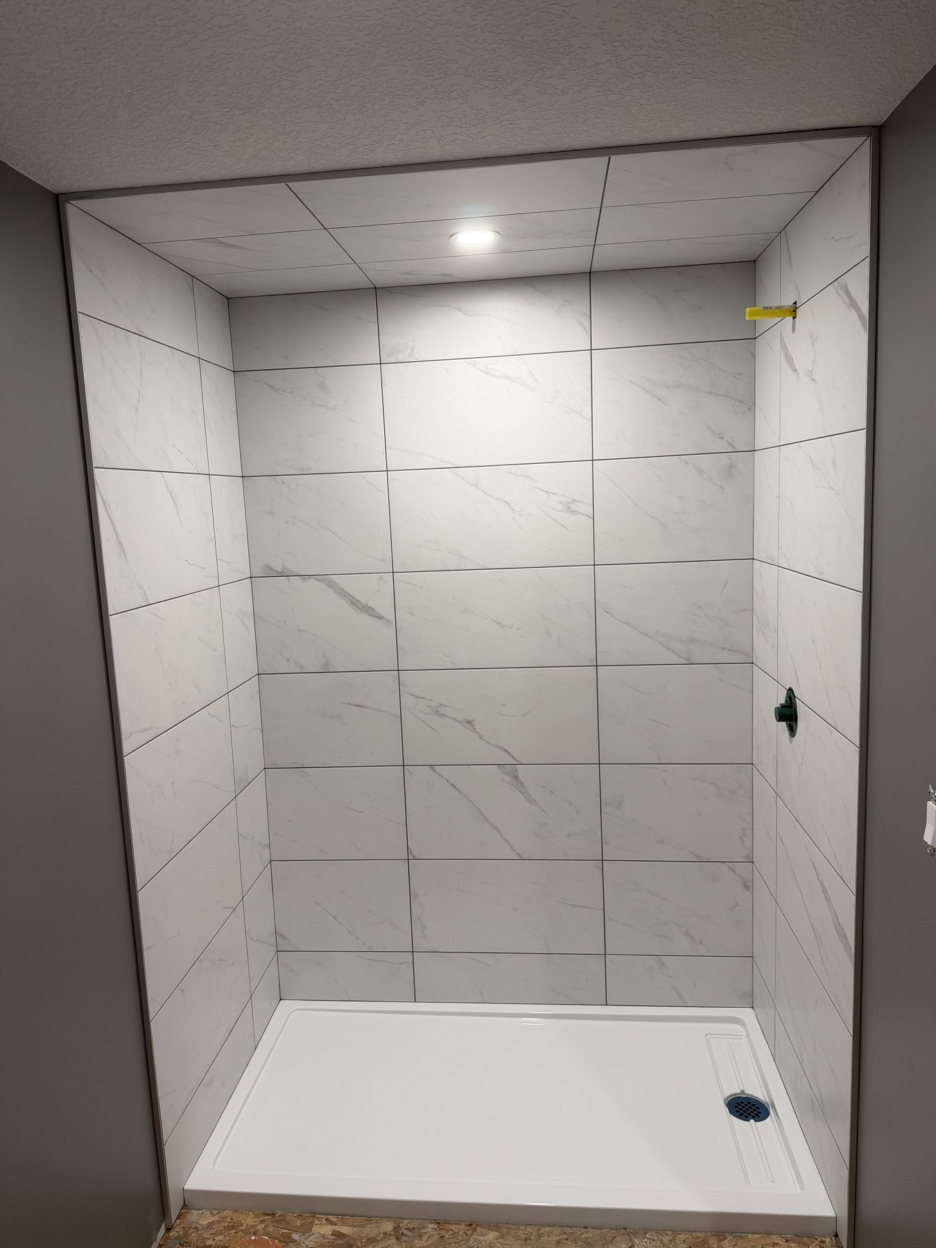 Marble-look shower wall tile installation